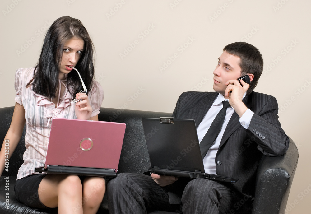 Businesspeople with laptops sitting on sofa Businesspeople with laptops sitting on sofa