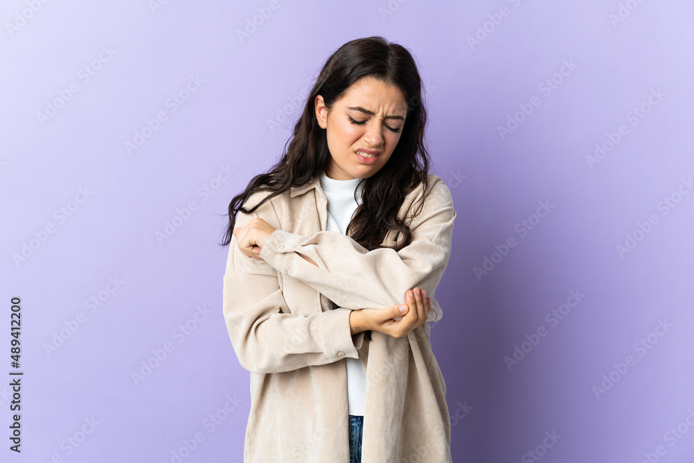 Young caucasian woman isolated on purple background with pain in elbow Young caucasian woman isolated on purple background with pain in elbow