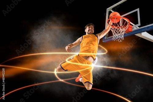 Basketball player players in action. Basketball on lightning background © Andrey Burmakin