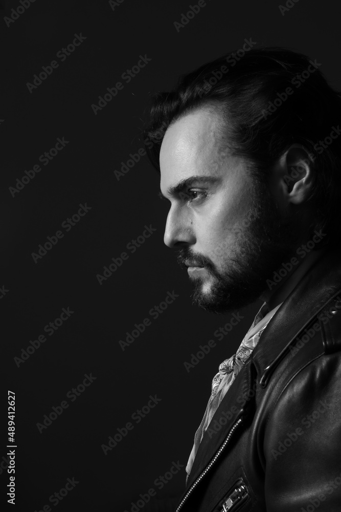 Black and white profile photo of bearded stylish handsome confident man. Indoor.