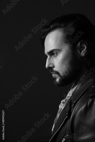 Black and white profile photo of bearded stylish handsome confident man. Indoor.