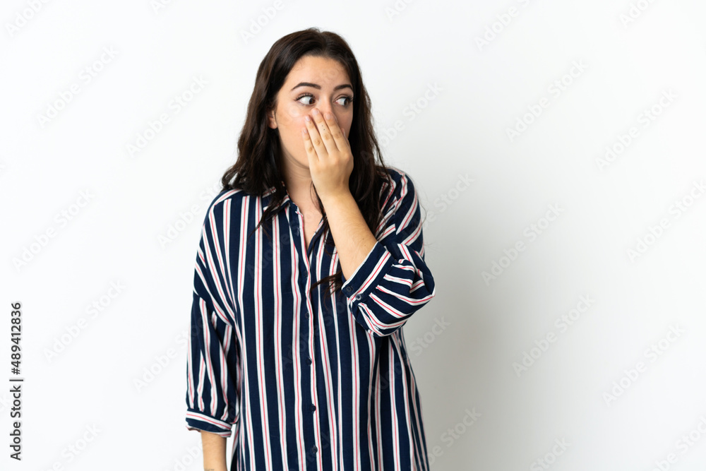 Young caucasian woman over isolated background doing surprise gesture while looking to the side Young caucasian woman over isolated background doing surprise gesture while looking to the side