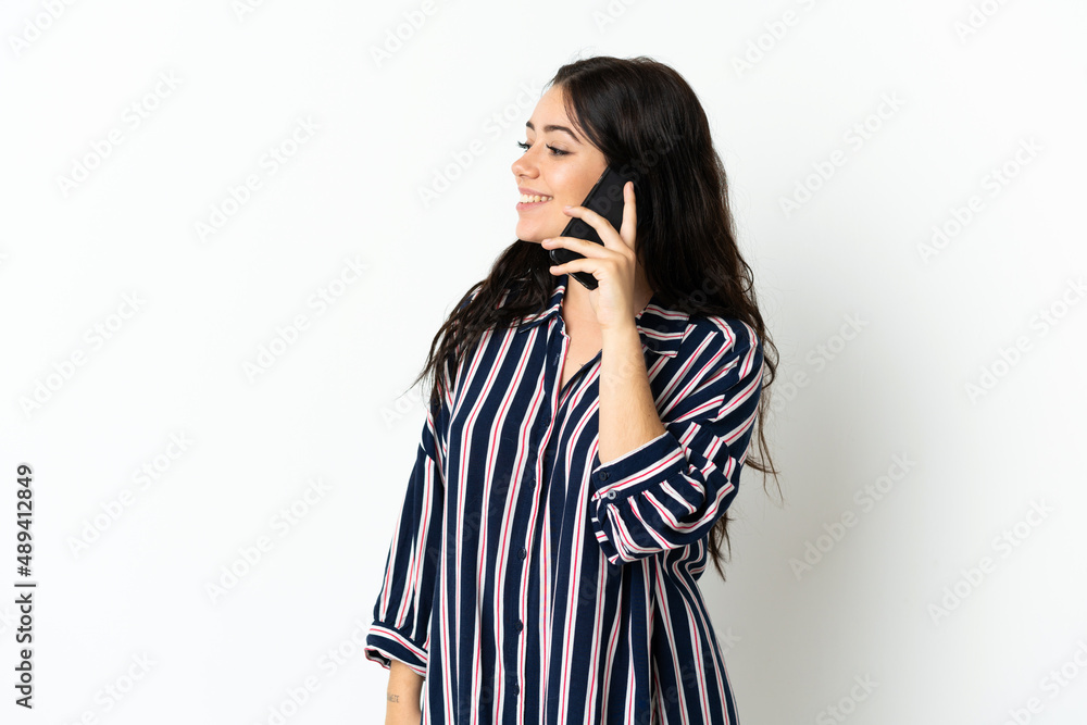 Young caucasian woman over isolated background keeping a conversation with the mobile phone with someone