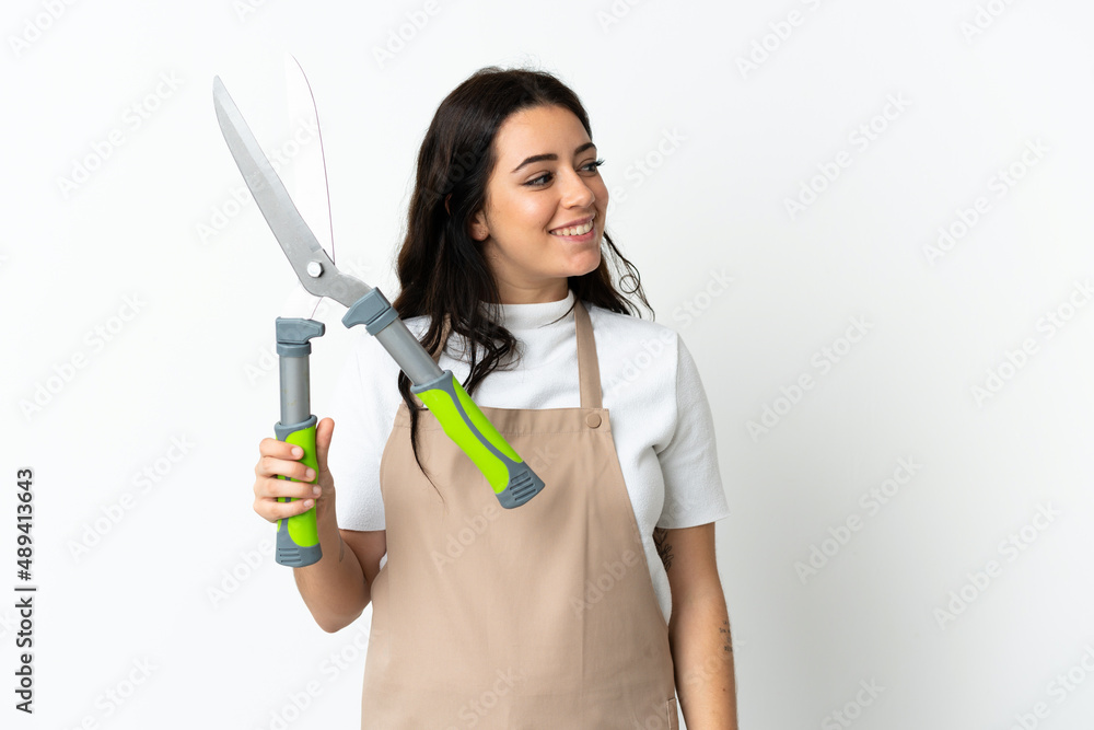 Young caucasian woman holding a plant isolated on white background looking side Young caucasian woman holding a plant isolated on white background looking side