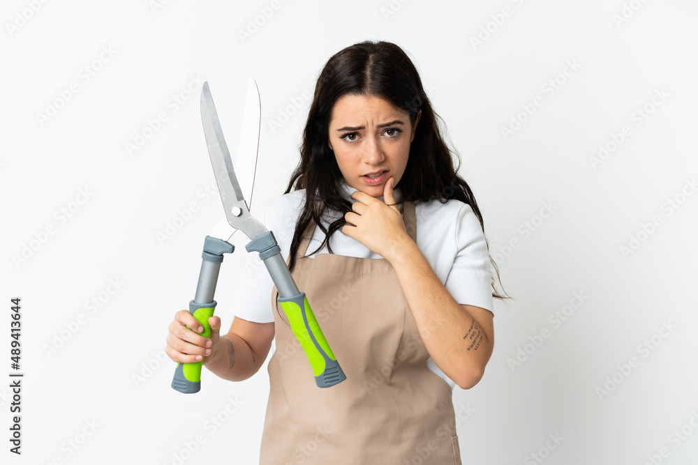 Young caucasian woman holding a plant isolated on white background thinking Young caucasian woman holding a plant isolated on white background thinking