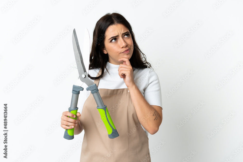 Young caucasian woman holding a plant isolated on white background and looking up Young caucasian woman holding a plant isolated on white background and looking up
