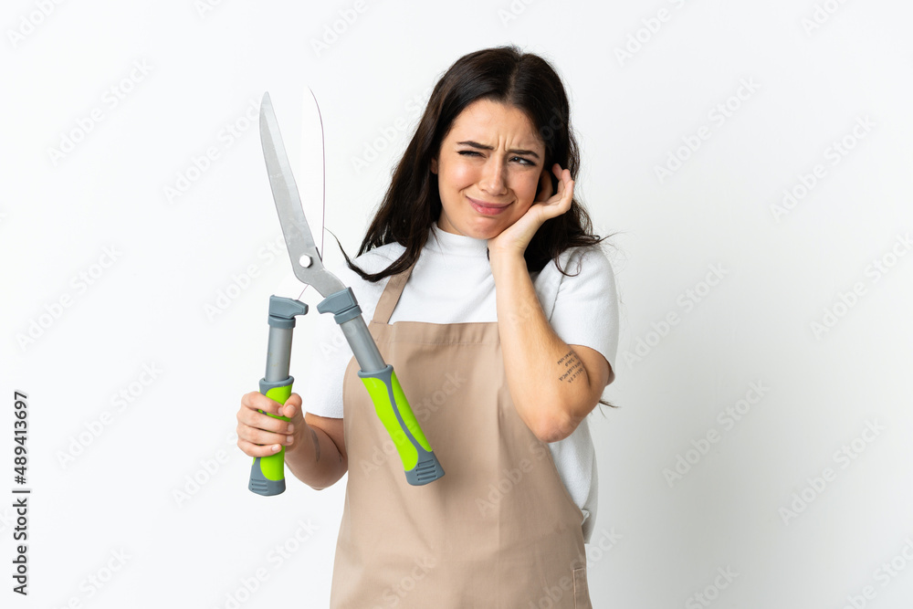 Young caucasian woman holding a plant isolated on white background frustrated and covering ears Young caucasian woman holding a plant isolated on white background frustrated and covering ears