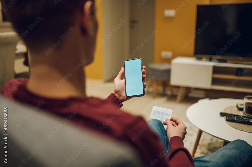 Man hands with smartphone and credit card while online shopping at home Man hands with smartphone and credit card while online shopping at home