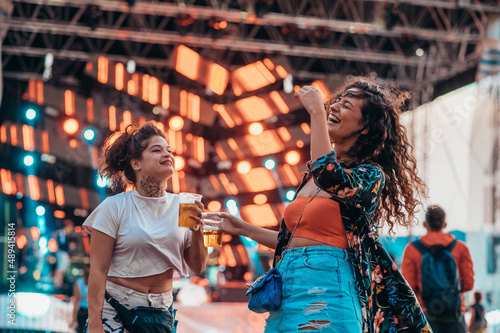 Sticker Two beautiful friends drinking beer and having fun on a music festival