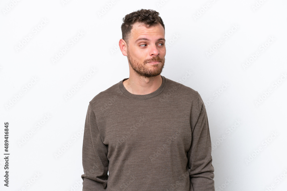 Obraz premium Young Brazilian man isolated on white background making doubts gesture looking side