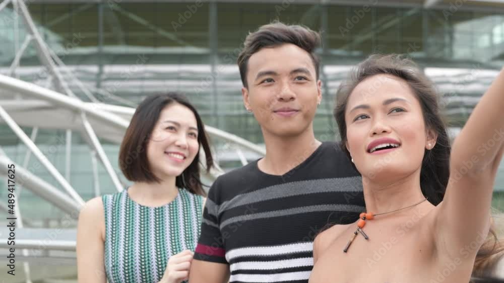 Three asian young people outdoor relaxing in the city Three asian young people outdoor relaxing in the city