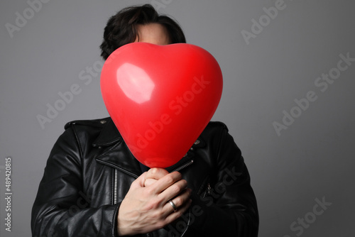 Love. Headshot of handsome young spanish man with inflating balloon.