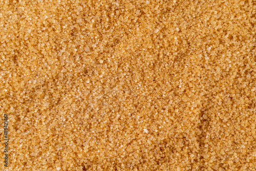 Background of brown raw sugar demerara, top view.