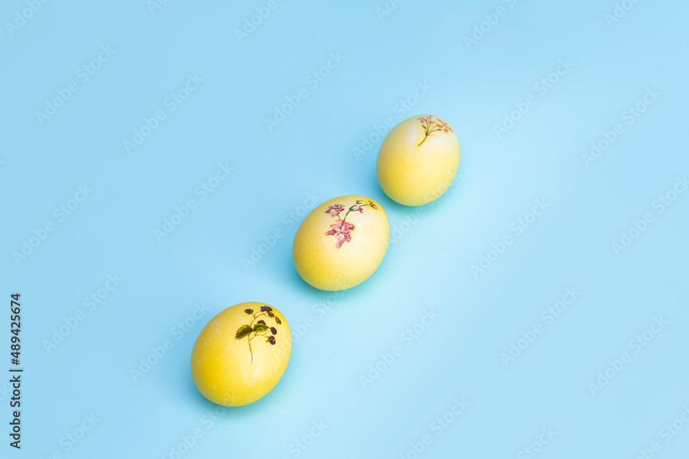 Bright yellow chicken Easter eggs lie in a row on a blue background. An opening to the Easter holiday Bright yellow chicken Easter eggs lie in a row on a blue background. An opening to the Easter holiday
