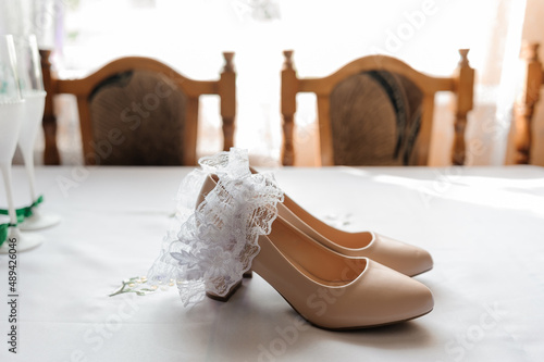 Bride's accessories. Women's shoes leather, garter, bridal bouquet, candles, pendant photo