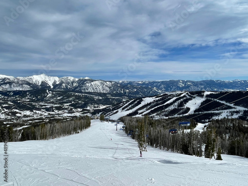 Scenic view of the snow covered slopes and mountains at Big Sky Ski Resort in Montana on a sunny winter day