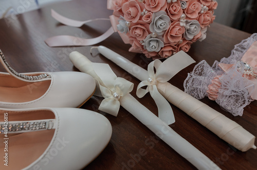 Bride's accessories. Women's shoes leather, garter, bridal bouquet, candles, pendant