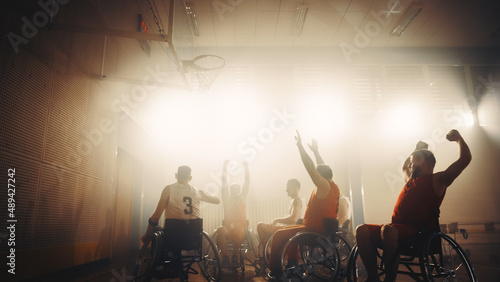 Wheelchair Basketball Game: Professional Players Competing, Shooting Ball Successfully, Score a Perfect Goal, Celebrate it with Raised Hands. Determination and Skill of a People with Disability. © Gorodenkoff