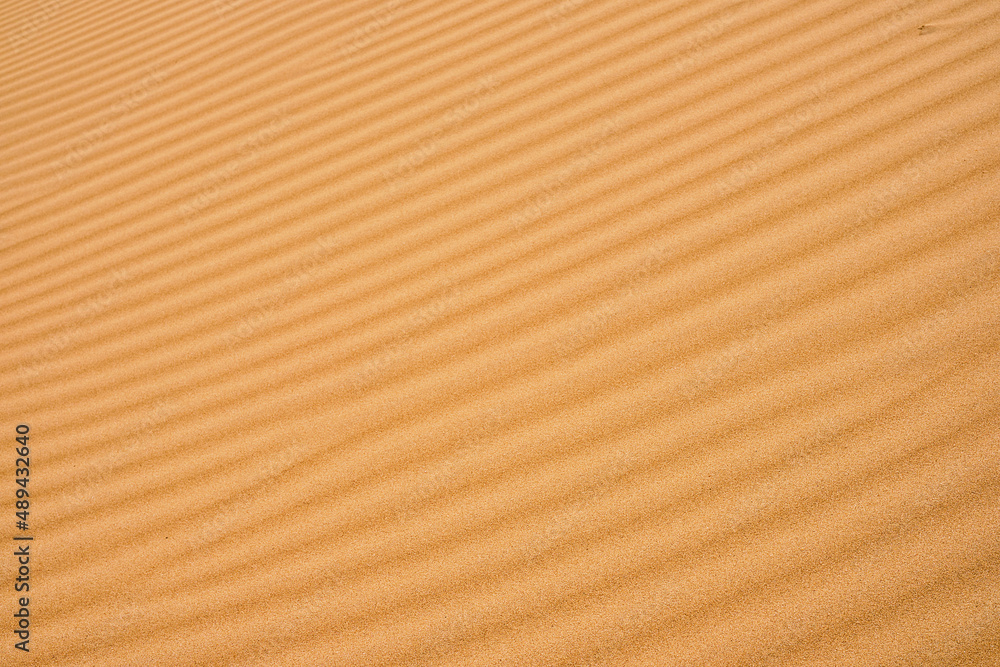 Wavy sand background for summer designs or backdrops. Natural sandstone texture background, sand on the beach as background. Wavy sand background for summer designs or backdrops. Natural sandstone texture background, sand on the beach as background.