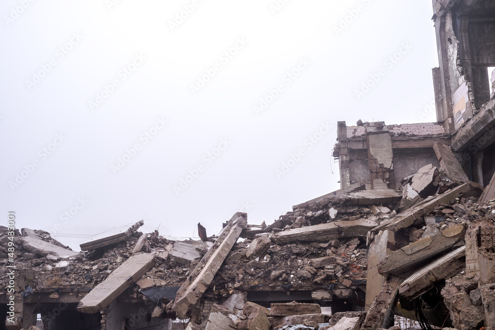 A pile of large concrete fragments of a large destroyed building in a foggy haze. Background A pile of large concrete fragments of a large destroyed building in a foggy haze. Background