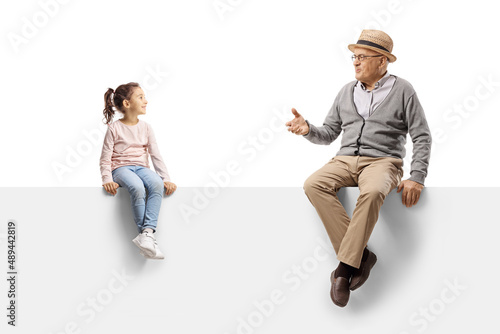 Obraz na płótnie Gentleman sitting on a blank panel and talking to a child