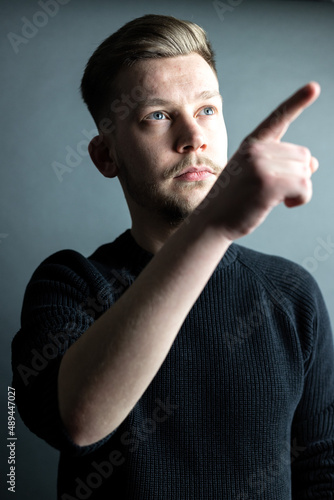 Junger Mann Portrait zeigt auf etwas