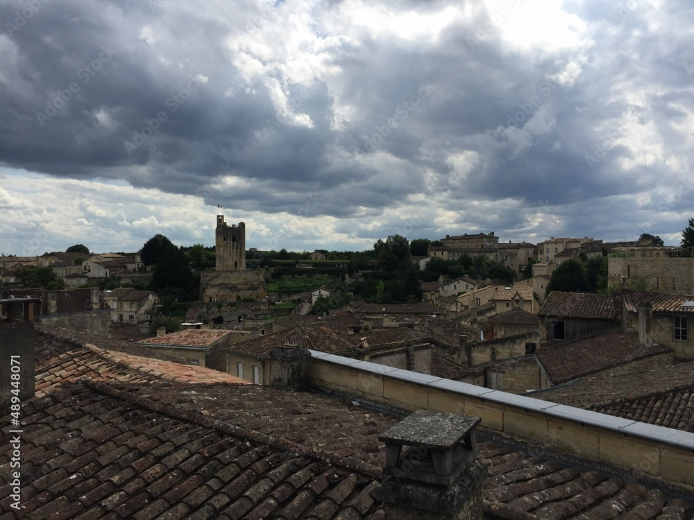 Saint Emilion, Bordeaux, France. Panoramic view of medieval town. Saint Emilion. Panorama view of the medieval town. Limestone houses with shutters and tile rooftop. Tour du Roy tower on a background.