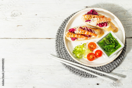 Open sandwiches with boiled shrimps, cream cheese, salad leaves, and Chuka salad. Seafood