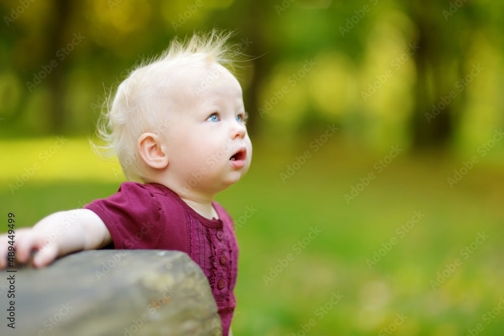 Adorable toddler girl having fun during a hike in the woods on beautiful sunny spring day. Active family leisure with kids. Adorable toddler girl having fun during a hike in the woods on beautiful sunny spring day. Active family leisure with kids.