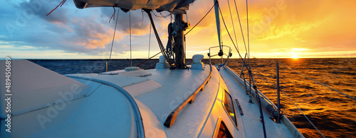 Obraz na plátně White yacht sailing in an open sea at sunset