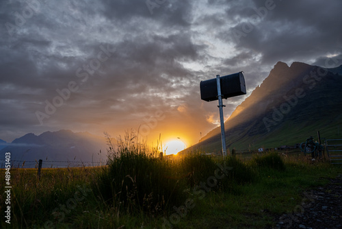 Beautiful Icelandic view of a magical sunset in the mountains with a lake reflection and a mailbox 