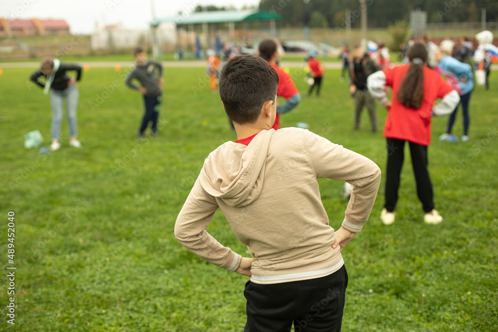 Schoolboy does gymnastics in park. Sports activity for children. Health Day in Russia.