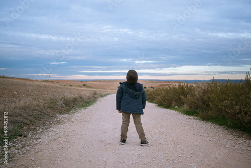 Boy in a road in a cloudy day