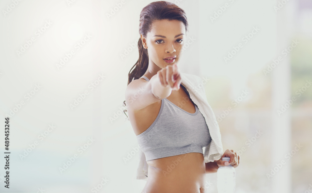 Start today. Cropped portrait of an attractive young woman pointing towards the camera during her workout at home.
