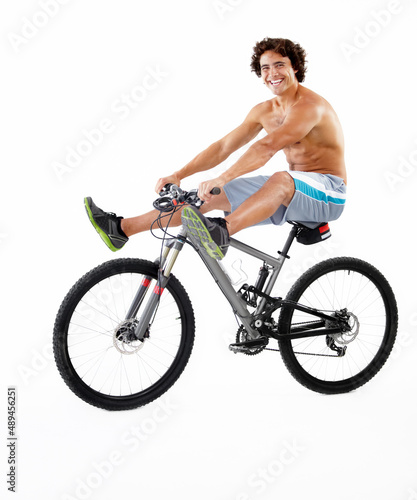 Goofing around for your entertainment. A sexy young man riding his bike on a white background.
