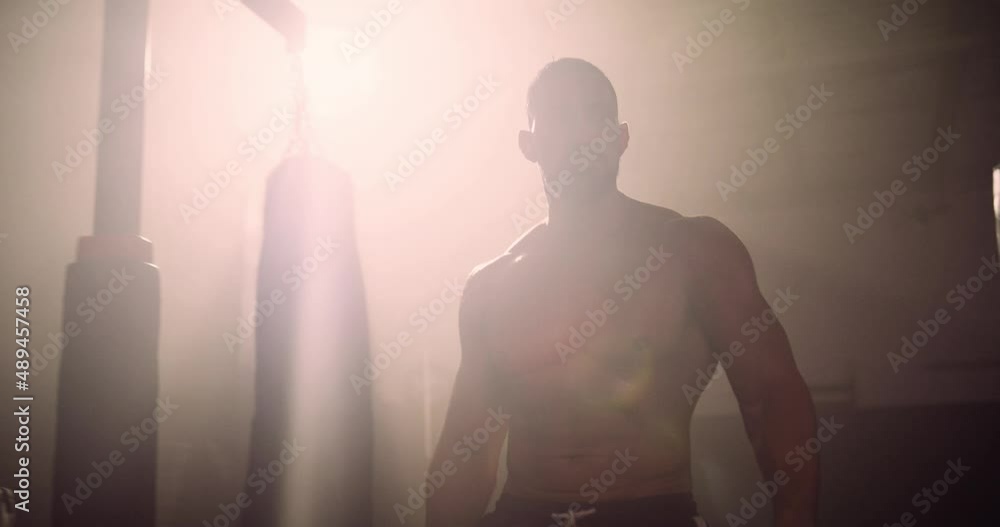 A Heavyweight Hispanic Boxer Exercises Battle Ropes In A Crossfit Gym. Shot In A Crossfit Boxing Gym With Low Key Lighting And A Scattering Of Haze. Captured On Red Digital Cinema Camera A Heavyweight Hispanic Boxer Exercises Battle Ropes In A Crossfit Gym. Shot In A Crossfit Boxing Gym With Low Key Lighting And A Scattering Of Haze. Captured On Red Digital Cinema Camera