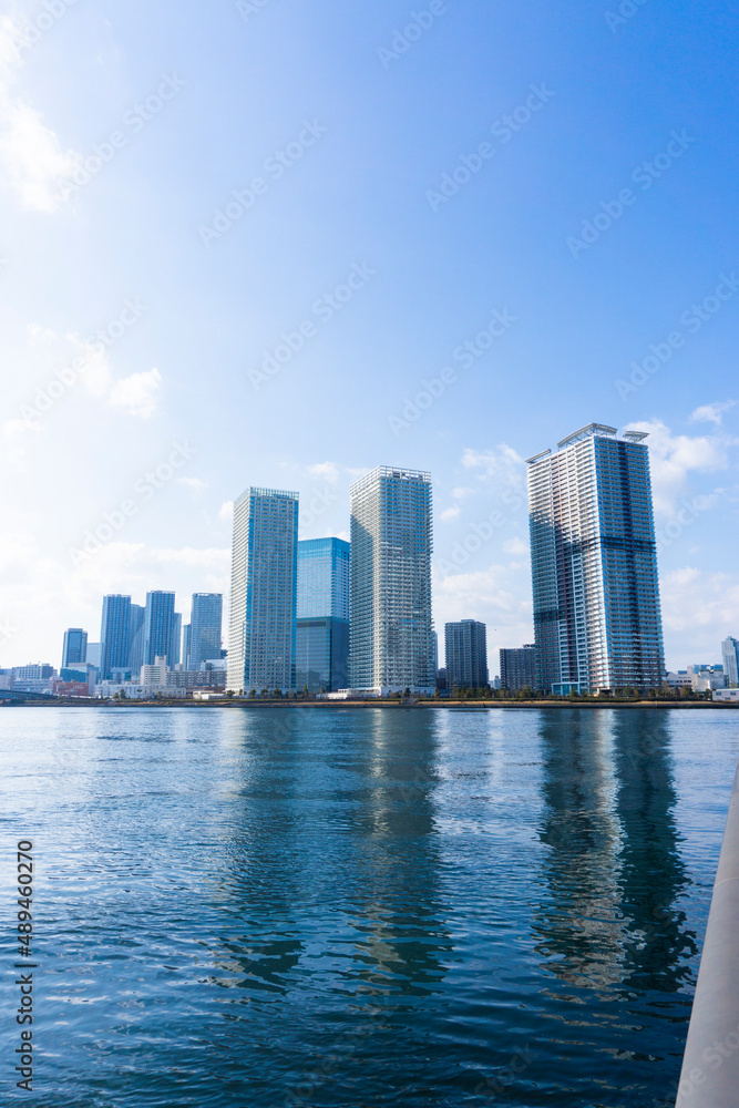 Obraz premium Tower apartments lined up along the river and a refreshing blue sky_26