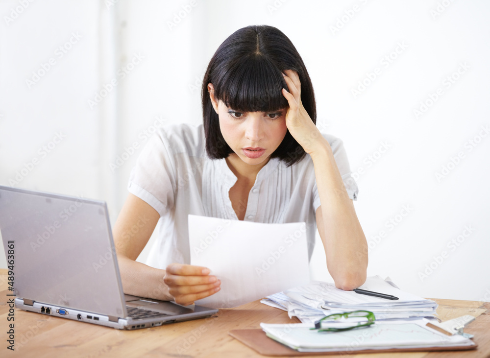 Ive gone way over budget. A shocked businesswoman reading the financial breakdown of her budget. Ive gone way over budget. A shocked businesswoman reading the financial breakdown of her budget.