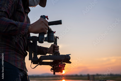 Filmmaker or content creator using stabilizer gimbal camera take video footage on the location outdoor photo