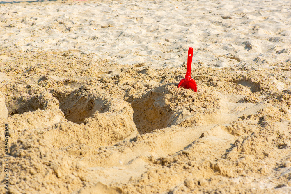 red shovel children sticks out in the sand red shovel children sticks out in the sand