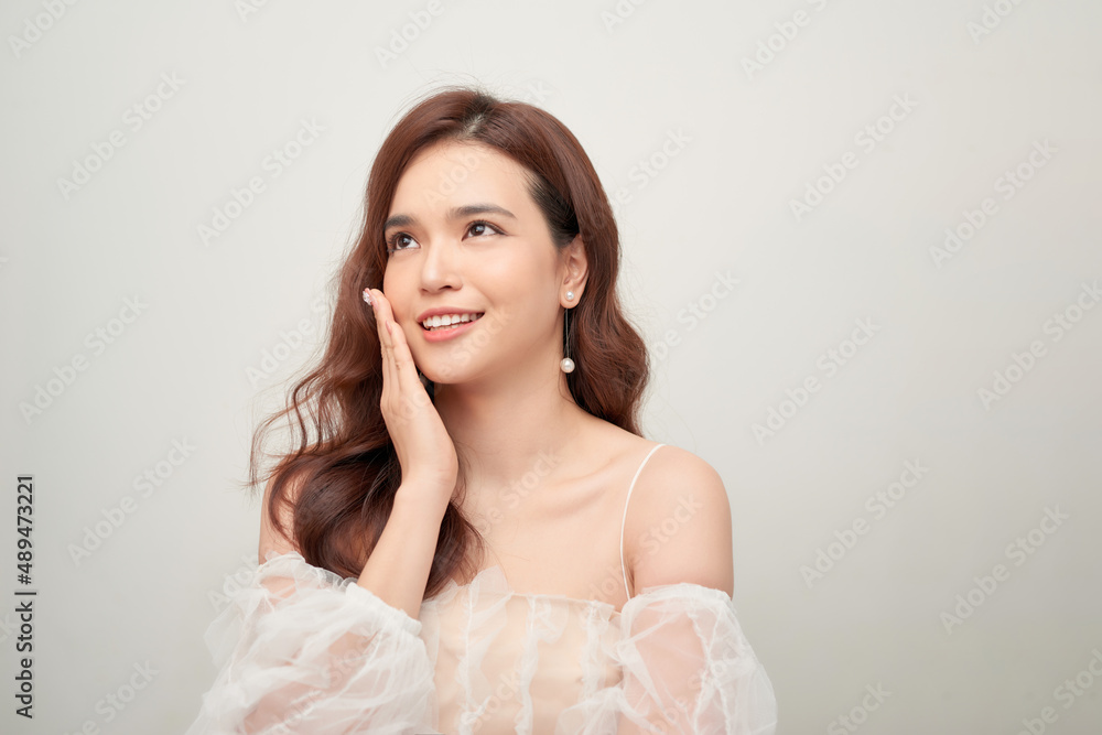 Beautiful portrait of asian young woman in white blouse on grey background. Beautiful portrait of asian young woman in white blouse on grey background.