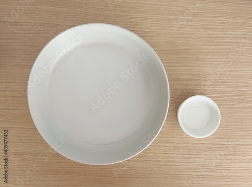 Top view white ceramic plate porcelain dish isolated on wooden table background. 