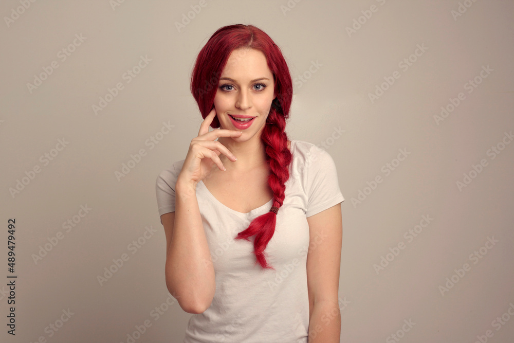 close up portrait of pretty female model with red hair in a braid, expressing emotion over the top facial expression on a studio background. close up portrait of pretty female model with red hair in a braid, expressing emotion over the top facial expression on a studio background.