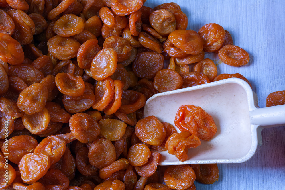 pitted dried apricots in a blue cardboard box with a scoop pitted dried apricots in a blue cardboard box with a scoop
