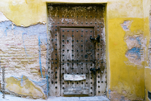 old door in the old wall in toledo spain, with a yellow wall.