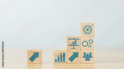 stacking wooden cube with improvement icon standing with goal. plan, action, and improvement concept.