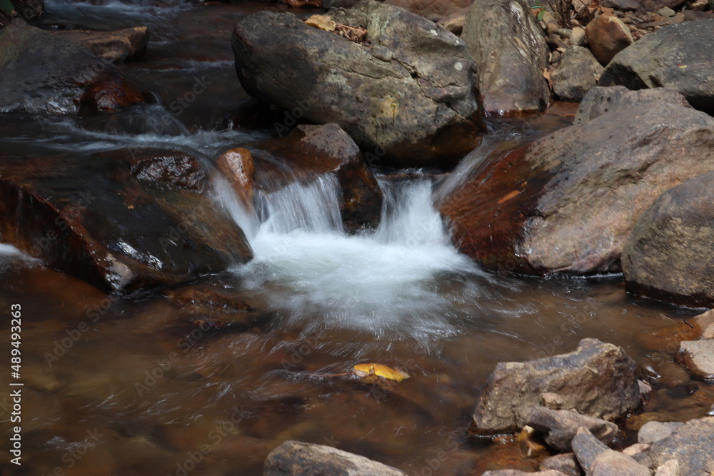 small waterfall or stream of water flowing freely and is shot in freezing time.