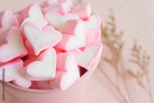 Fluffy pink heart marshmallow in small tank on pink background. Love and dessert concept.