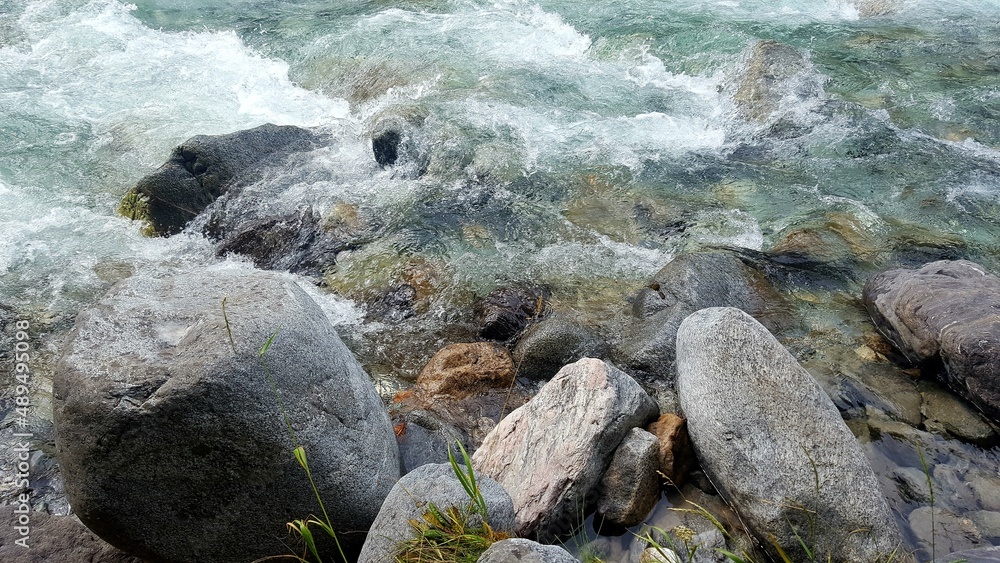 Obraz premium rapid flow of a mountain river between large stones. The beauty of two elements