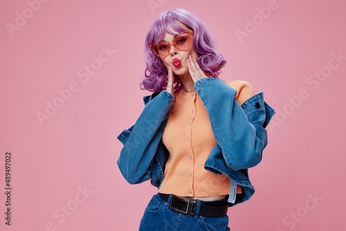 Beautiful fashionable girl purple hairstyle red lips denim jacket fun pink background unaltered